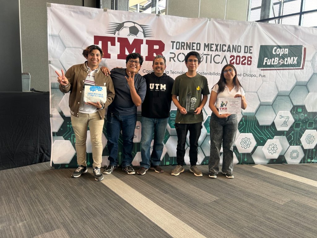 Integrantes del equipo AUTÓNOMO con el trofeo y el diploma frente al panel oficial del TMR 2026